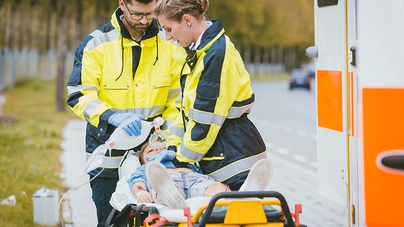 Emergency doctor giving oxygen to accident victim, a child