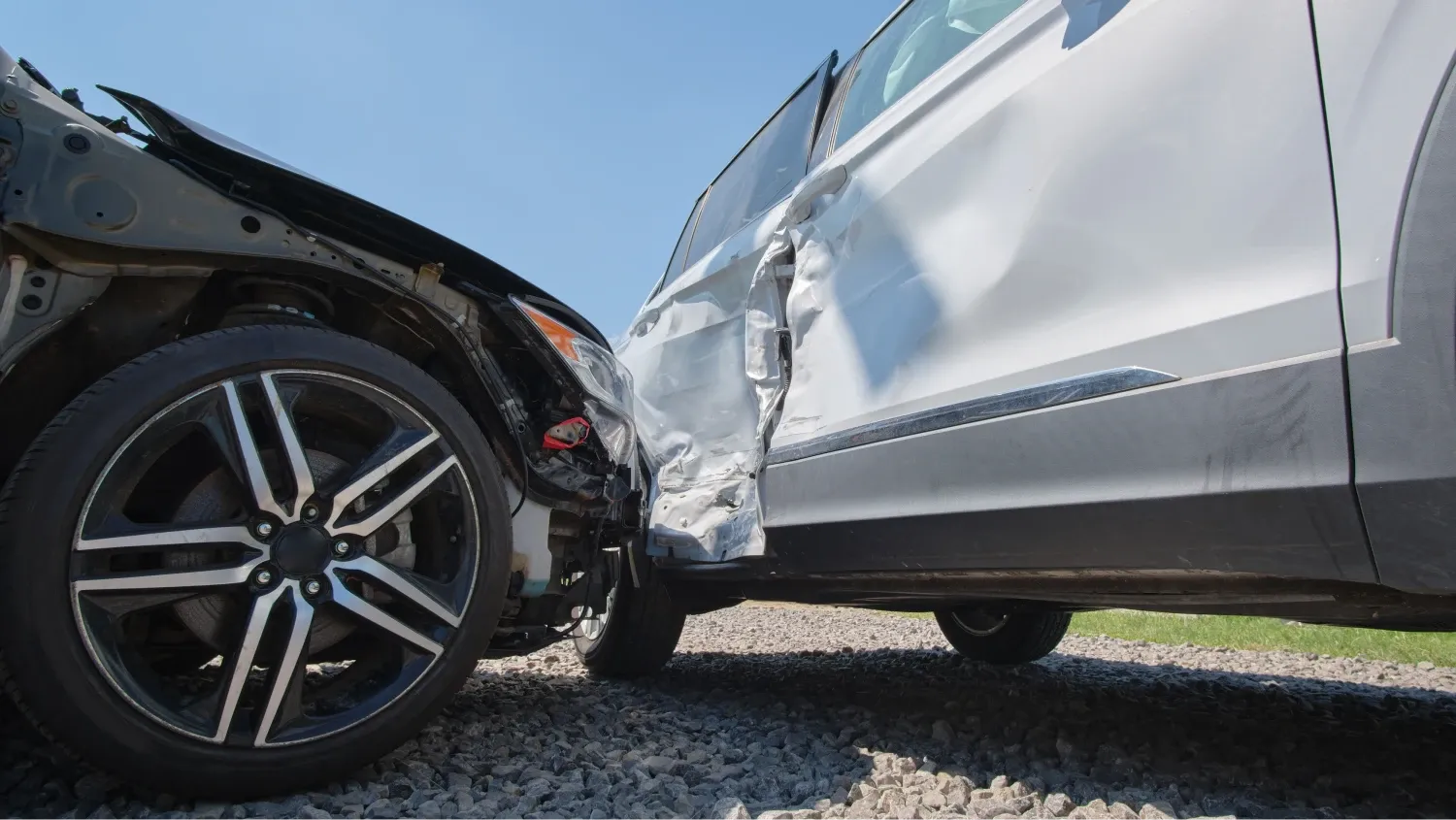 two vehicles involved in a car accident, and the impact has caused significant damage to the passenger side doors of the SUV, which are crushed inward.