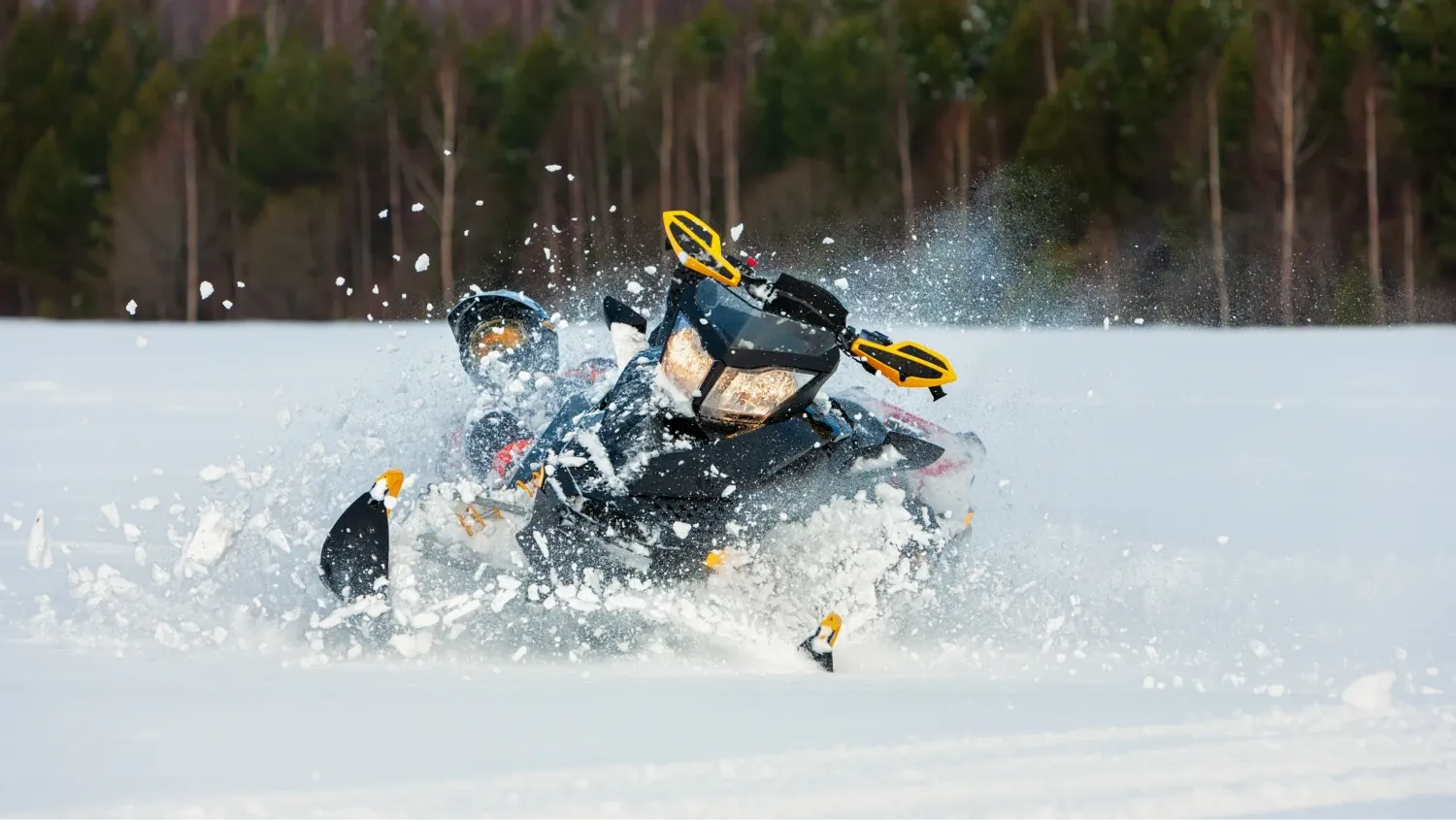 The snowmobile is kicking up a large spray of white powder, suggesting it's moving at speed or turning sharply, it is navigating a snowy, open field.