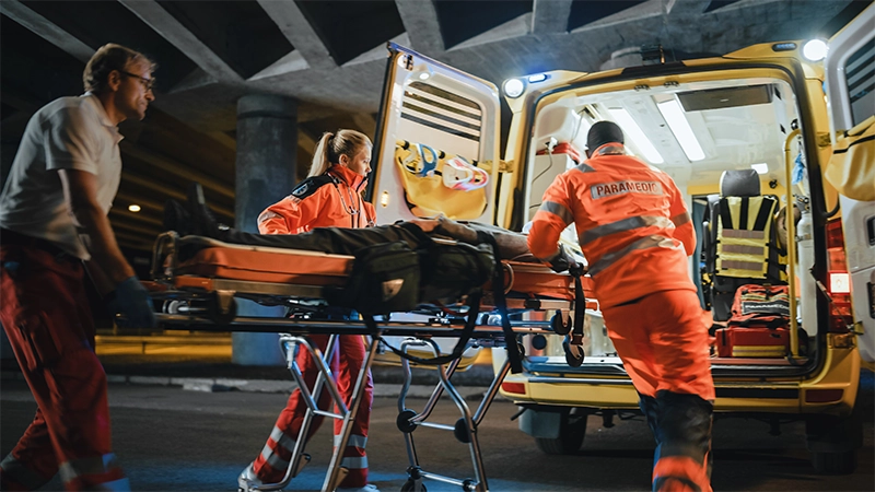 Paramedics React Quick to Provide Medical Help to Injured Patient and Get Him in Ambulance on a Stretcher.